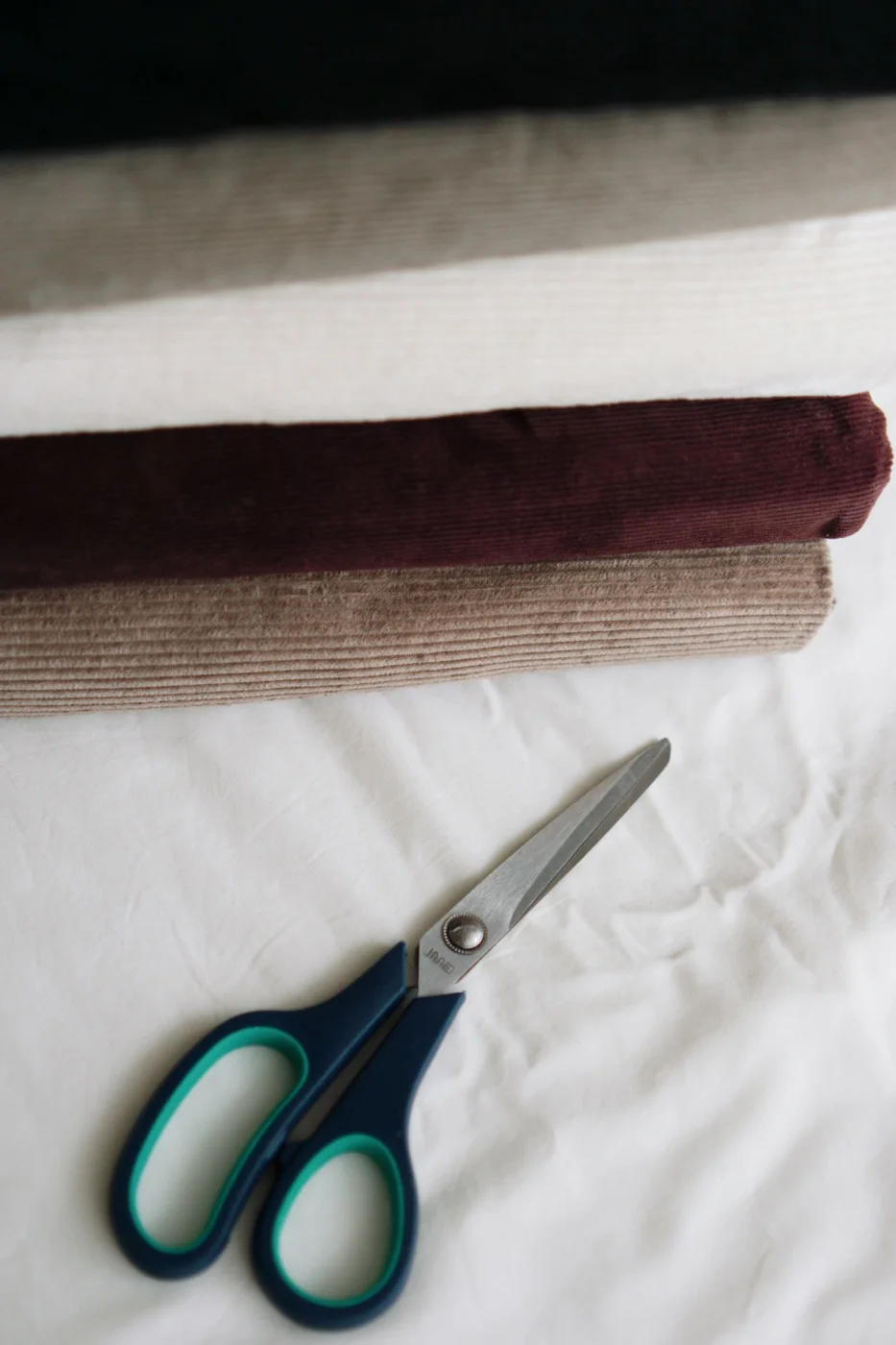 An assortment of fabric rolls and sewing scissors